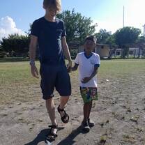 Volunteer walking across field with student