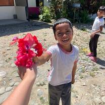 Child holding out a paper flower