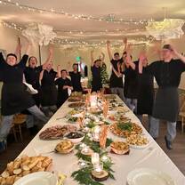 Kitchen team standing around table full of food
