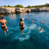 people jumping into ocean