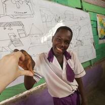 Using our bodies to create creative designs. Volunteer Anna and a student makeing Love sign
