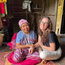 An older Karen women holds the hand of a younger woman