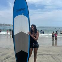 a girl standing with a surf board