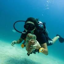 a scuba diver holds trash 