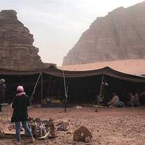 People standing near and under a makeshift tent.