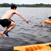 boy jumping into a river