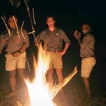 group standing around a fire at night