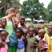 Children posing for a pic with a volunteer
