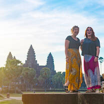 two girls standing in front of a landmark in Angkor Wat