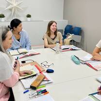 students around a table with books