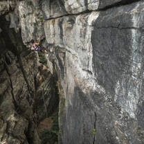 A climber scales a cave wall