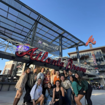 group smiling in front of a sports stadium