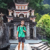 man in front of a temple in Vietnam 
