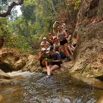 a group poses for a photo on a river bank