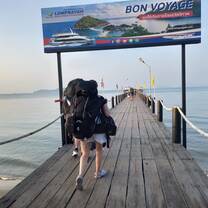 a girl walks with backpacking backpack on a pier