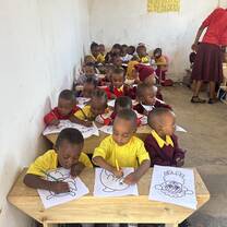 rows of young students at desks coloring photos 