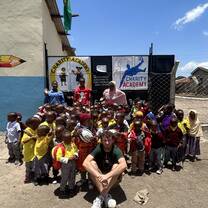 volunteer with large group of children and teachers