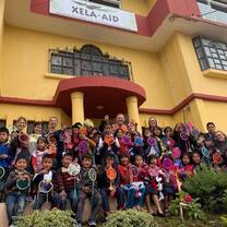 Large group of people in front of yellow building