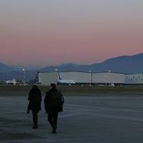 Students walk on the tarmac in front of the mountains