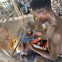 boy practicing traditional kente weaving 