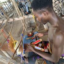 boy practicing traditional kente weaving 