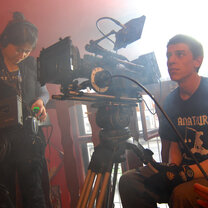 male student manning a large film camera 