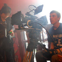 male student manning a large film camera 