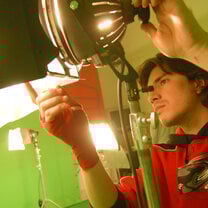 male student changing settings on stage light 