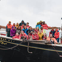 A group photo of people on a schooner.