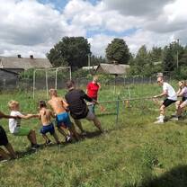 volunteers and young kids playing tug-of-war