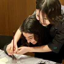 Women learning traditional calligraphy