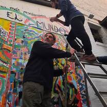Man holding stairs for a student when wall painting