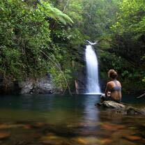 Student siting at a waterfall in the Jaguar Reserve