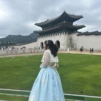 Student wearing a gown in front of a building