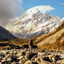 Student stands in front of a beautiful mountain