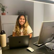 Student smiling in front of computers