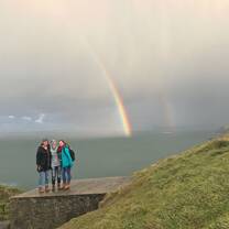 Students pose for a picture in front of a beautiful rainbow!