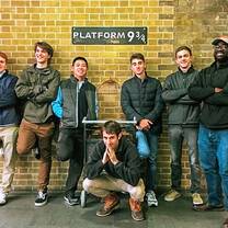 Students/wizards pose in front of Platform 9 3/4 (Harry Potter)