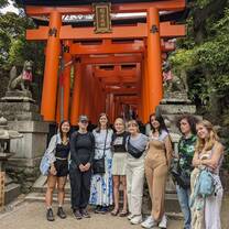 group smiling in front of red gate