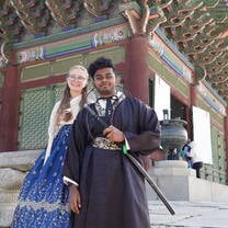 Students in traditional dress in front of temple