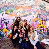 Students pose for a picture in front of artwork/graffiti