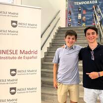 Men next to INESLE banner