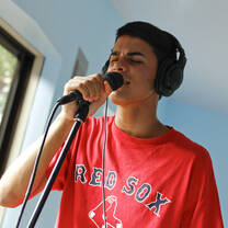 Student recording vocals in music studio at New Summit Academy