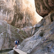 LITA students hiking on a path through gigantic rocks and next to a small river
