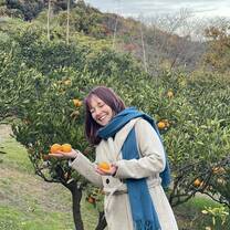 Picture of one of our students holding Mikan while enjoying hanging out with locals