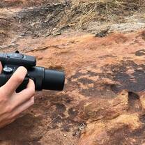 Volunteer taking a picture at land