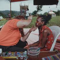 Volunteer face painting a girl