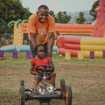 Volunteer pushing girl on skelter