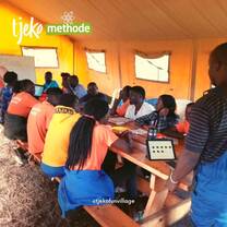 Staff members sit around wooden table for meeting