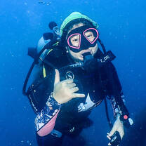 Student is scuba diving and giving a thumbs up